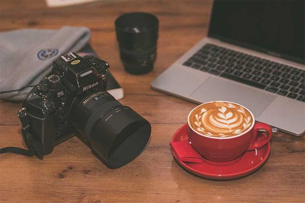 laptop, camera and a hot cup of coffee